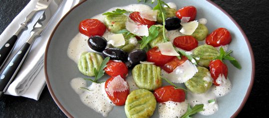 Rucola-Gnocchi mit Pomodorini, Oliven und Zitronenschaum
